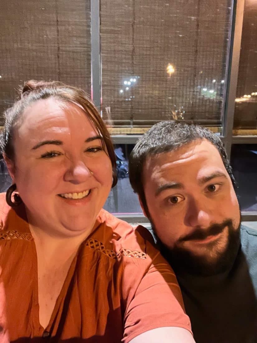 Robbie and Caitlin smiling together at Kuma Sushi on their first date