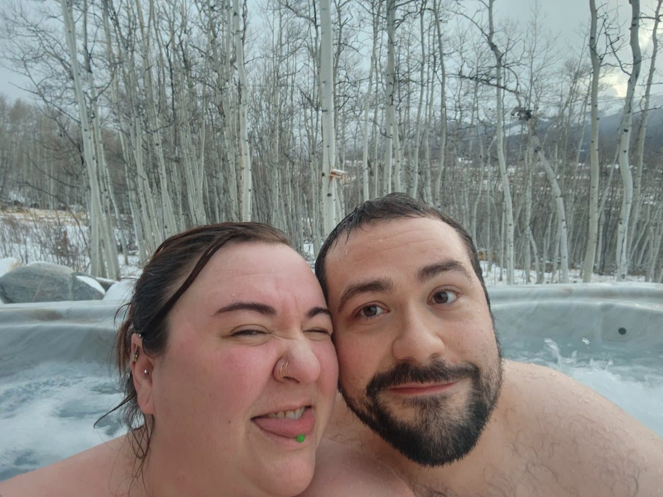 Robbie and Caitlin in a hot tub surrounded by snowy aspens outside Vail, just after the proposal